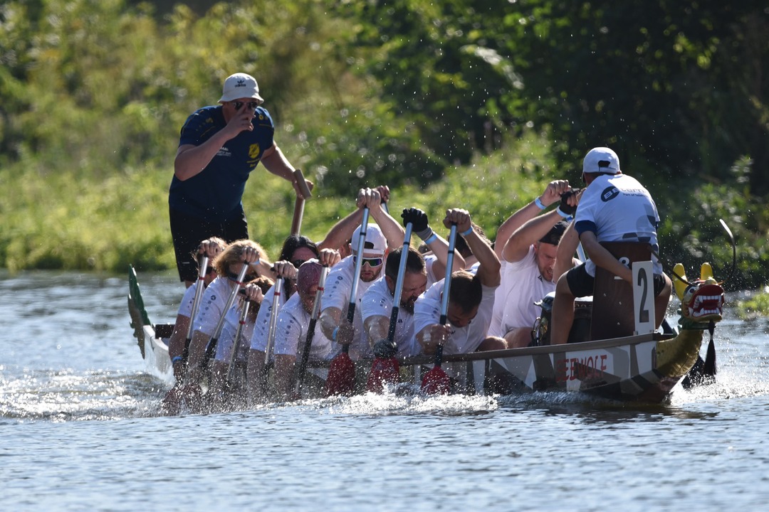 BE-terna employees paddling together in dragon boat race showcasing teamwork, company sports events, and collaborative culture.