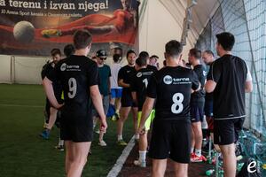 BE-terna employees in team jerseys at indoor football match, promoting active workplace culture and employee sports engagement.