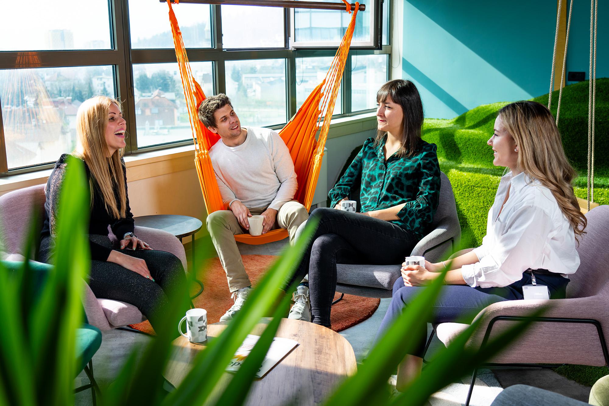 BE-terna employees having informal meeting in modern office lounge.