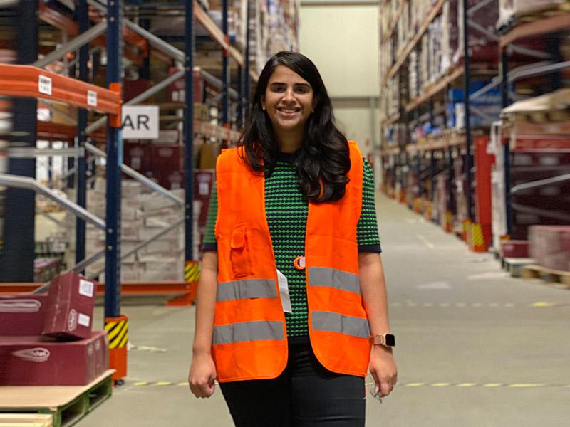 Parul Saigal standing in  warehouse wearing high-visibility vest.