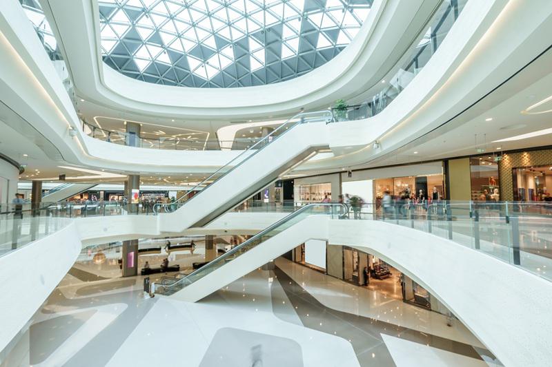 Modern shopping mall with escalators and open retail spaces – representing the retail sector
